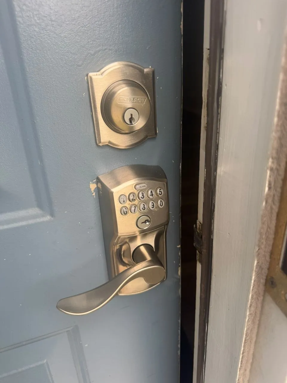 Keypad deadbolt and matching lever handle fitted on a grey front door.
