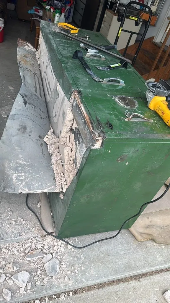 Steel safe on a garage floor during a safe job.