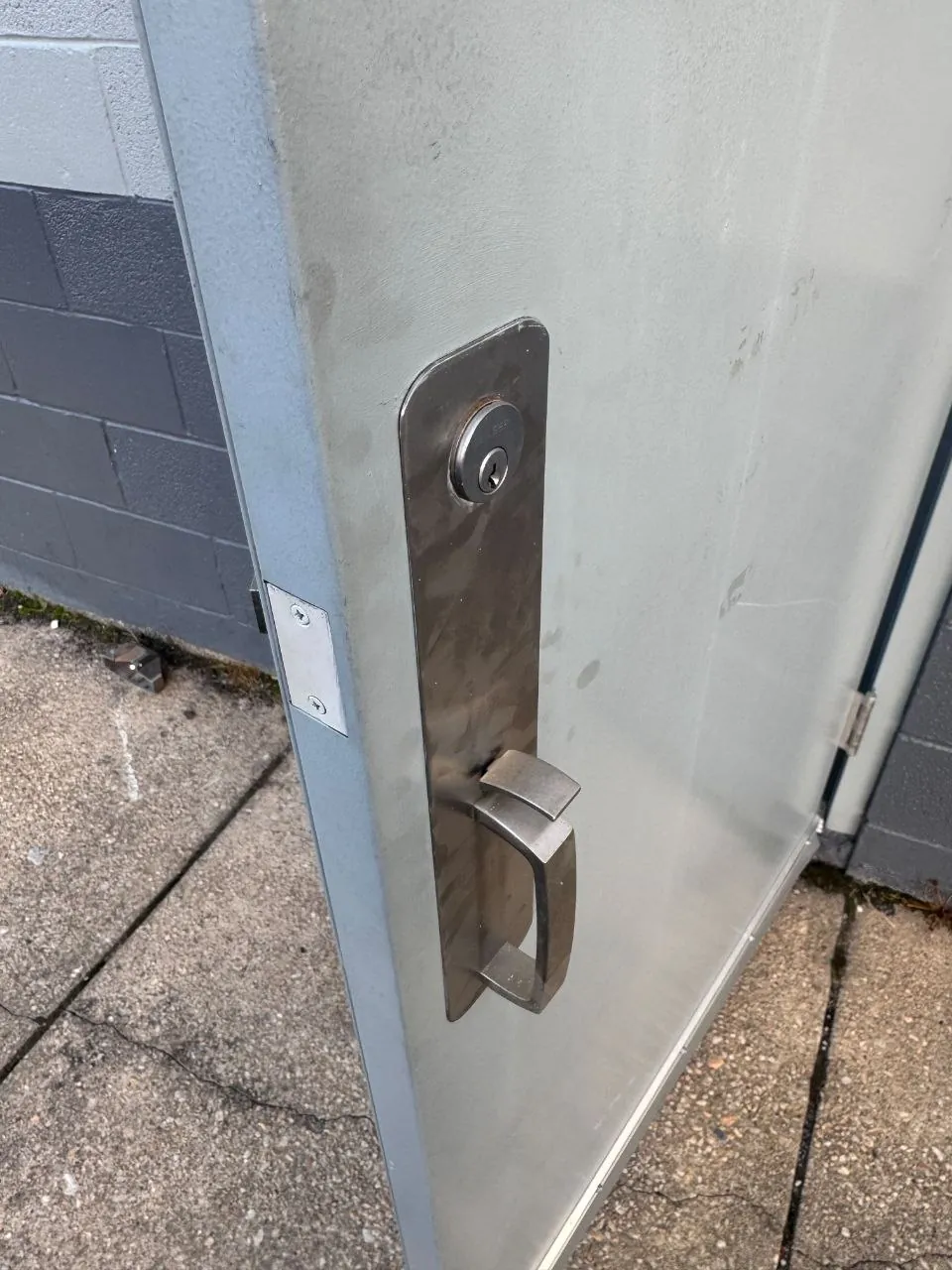 Pull handle with a key cylinder on a metal storefront door.